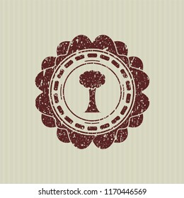 Red tree icon inside distressed rubber seal
