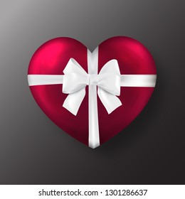 Red Valentine's day heart with white bow on black background