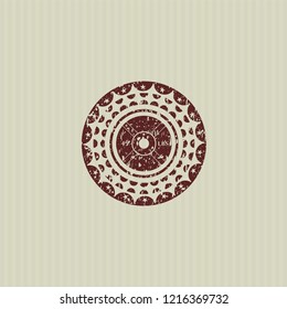 Red weightlifting or powerlifting plate (45 lbs) icon inside rubber stamp with grunge texture