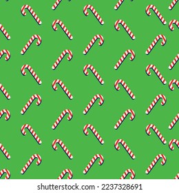 Red and white lollipops on green background. Christmas pattern. Seamless pattern.