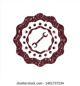 Red wrench icon inside distressed rubber seal