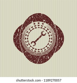 Red wrench icon inside rubber grunge texture stamp