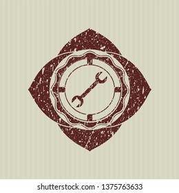 Red wrench icon inside rubber texture
