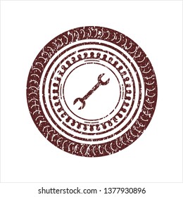 Red wrench icon inside rubber texture