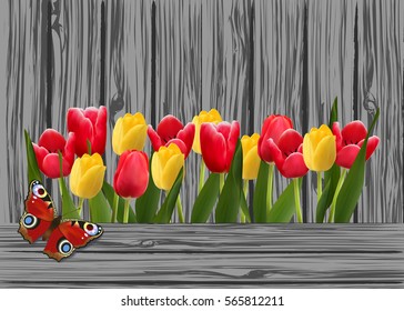 red and yellow tulips on old grey wooden boards