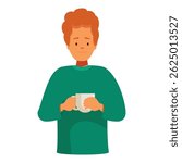 Redhead man wearing green sweater warming his hands on a mug of warm beverage