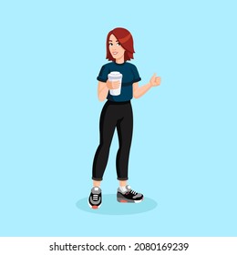 Redheaded sporty girl in sportswear with cup of coffee in her hands, shows thumbs up.