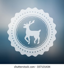 Reindeer badge vector with rounded designs placed on a blue blur background. Deer logo with a winter style defocused background.