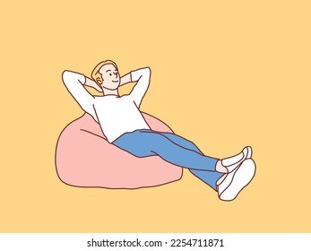 Joven alegre y relajado se inclina en beanbag simple ilustración de estilo coreano