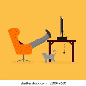 Relaxed man sitting on chair with feet on the table and watching something on the desktop computer