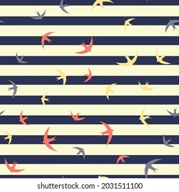 Repeat seamless pattern of abstract birds flying over navy and cream horizontal stripes