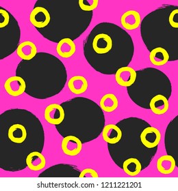 Repeated circles and round spots painted with rough brush. Bright geometric seamless pattern. Grunge, sketch, watercolor. Vector illustration. Purple, black, yellow.