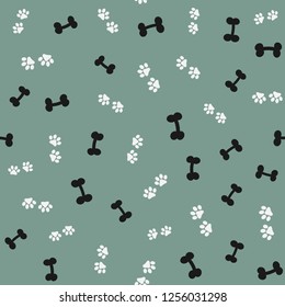 Repeated silhouettes of bones and animal paw prints. Seamless pattern for pets. Vector illustration.