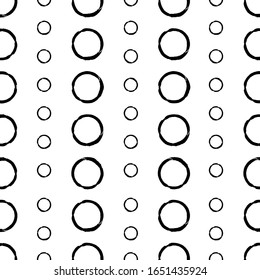 Repeating background of small and large circles. Black rings on a white background.