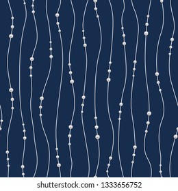 Repeating pearl necklace on blue backdrop. Seamless pattern. Chains of pearls forming an ornament. Realistic strands of pearls, decorative element for cards, wedding invitations. Threads of pearls 
