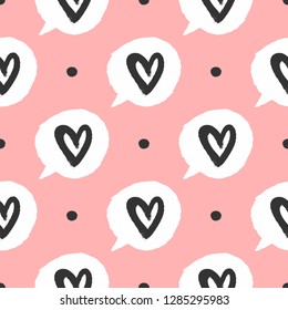 Repeating round dots and bubbles of speech with outlines of hearts. Cute seamless pattern drawn by hand with a rough brush. Sketch, watercolour, paint. Vector illustration. Pink, white, black.