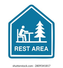 Rest area sign with a person sitting at a desk and a pine tree
