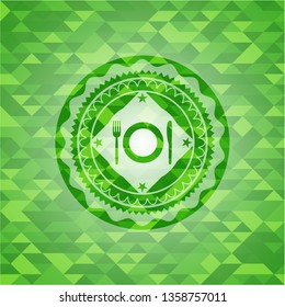 restaurant icon inside green emblem with triangle mosaic background