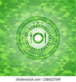 restaurant icon inside green emblem with triangle mosaic background