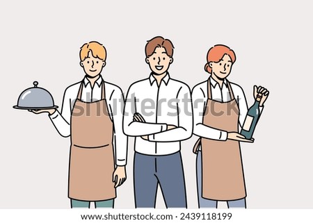 Restaurant waiters and administrators are ready to serve guests, want to have lunch or dinner. Male manager of cafe or lounge bar trains waiters to work in catering and horeca industry