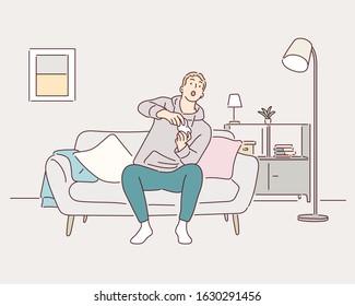 Resting at home. Handsome young  man playing video games and laughing while sitting on the sofa at home. Hand drawn style vector design illustrations.