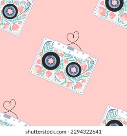 Retro-Audio-Kassette mit Blumen in nahtlosen Mustern. Magnetband in Form eines Herzens, Valentins Tageskonzept. Handgezeichnete Vektorgrafik-Illustration im einfachen Stil. rosafarbener Hintergrund