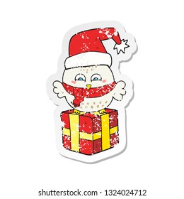 retro distressed sticker of a cartoon cute christmas owl on gift