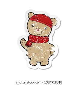 retro distressed sticker of a cartoon teddy bear in winter hat and scarf