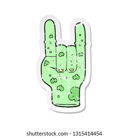 retro distressed sticker of a cartoon zombie hand making horn sign