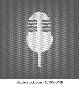 Retro microphone sign. Vector. White knitted icon on gray knitted background. Isolated.
