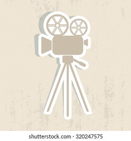 Retro movie camera icon on scratched background