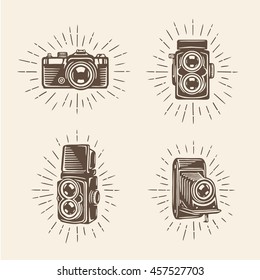 Retro photo cameras set. Design elements for photography related advertising, t-shirt prints, labels, badges, posters. Signs for photographer logo. Hand drawn vector vintage illustration.