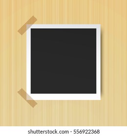 Retro photo frame on the sticky tape on the background of wooden wall, vector illustration