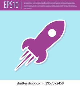 Retro purple Rocket ship with fire icon isolated on turquoise background. Space travel. Flat design. Vector Illustration