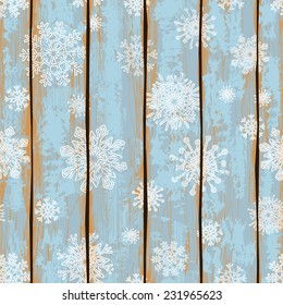 Retro seamless pattern with snowflakes on a wooden boards background