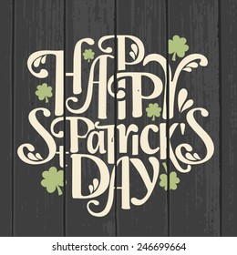 Retro style typographic design for Saint Patrick's Day on a gray wood background.