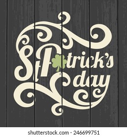 Retro style typographic design for Saint Patrick's Day on a gray wood background.
