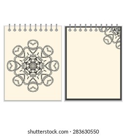 Ring-bound notebook with hand drawn black round pattern with snakes elements on white cover and pages. Isolated on white