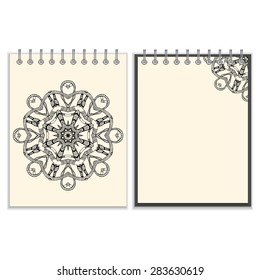 Ring-bound notebook with hand made black round pattern with snakes elements on white cover and pages