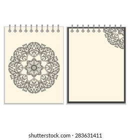 Ring-bound notebook with hand made black round pattern with snakes elements on white cover and pages, isolated on white background