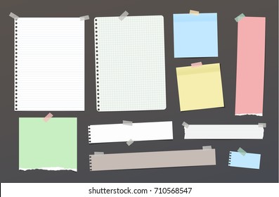 Ripped blank ruled note, notebook, copybook paper strips, sheets stuck with colorful sticky tape on dark background.