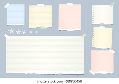 Ripped colorful, pastel note, notebook, copybook strips stuck with sticky tape and stars on blue background.