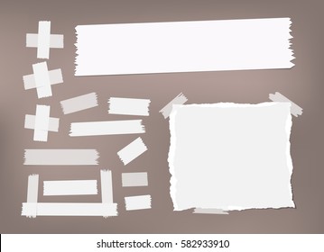 Ripped white notebook, copybook, note paper, sticky, adhesive masking tape stuck on brown background