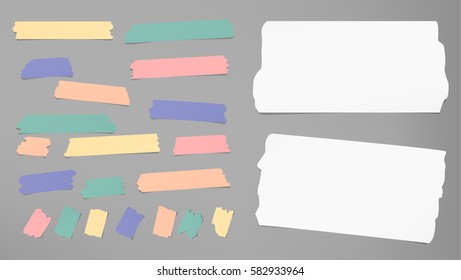 Ripped white notebook, copybook, note paper strips, colorful sticky, adhesive masking tape stuck on gray background