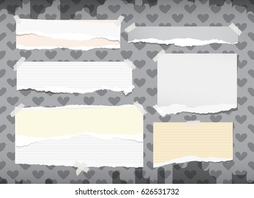 Ripped white and yellow notebook, copybook, note paper strips stuck with sticky tape on grey pattern created of heart shapes