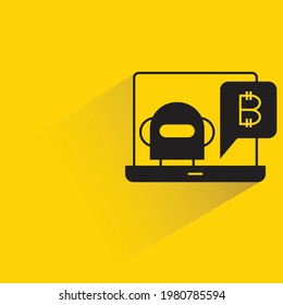 robot and bitcoin on laptop with shadow on yellow background