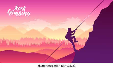 Rock climber resting while climbing overhanging cliff. Man climbing on rock, mountain at sunset. Extreme sports on a cliff over the foggy mountain valley in a light of sunrise