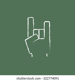 Rock and roll hand sign hand drawn in chalk on a blackboard vector white icon isolated on a green background.