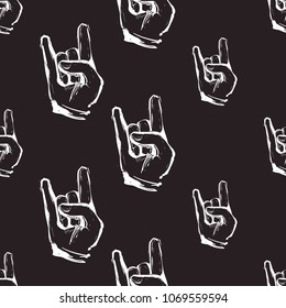Rock and roll seamless pattern with rock gesture. Vector hard rock doodle illustration. Cartoon rock star iconic backdrop for music band, concert, party. Isolated on black background.