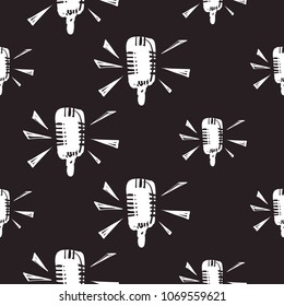 Rock and roll seamless pattern with microphone. Vector hard rock doodle illustration. Cartoon rock star iconic backdrop for music band, concert, party. Isolated on black background.